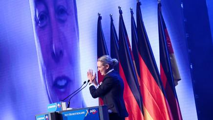 Alice Weidel, co-leader of the Alternative for Germany party (AfD), claps as SpaceX CEO Elon Musk is seen on screen during a central election campaign event of the AfD in Halle (Saale), Germany, January 25, 2025.