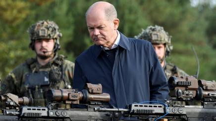 German Chancellor Olaf Scholz looks at weapons during a visit to a military base of the German army Bundeswehr in Bergen, Germany, October 17, 2022.
