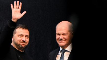 DOCUMENT DATE:  14 May, 2023  German Chancellor Olaf Scholz looks on as Ukraine's President Volodymyr Zelenskiy waves from the stage on the day of receiving Germany's prestigious Charlemagne Prize (Karlspreis) during the ceremony in Aachen, Germany, May 14, 2023.