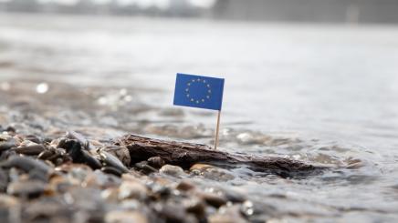 Photo of an EU flag surrounded by water