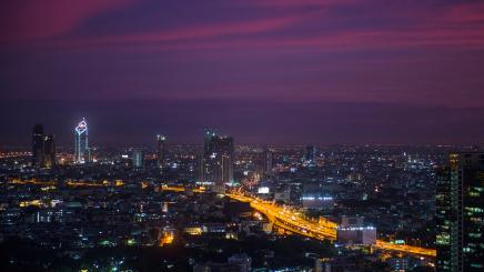 Photo of an Asian city by night with lights from moving traffic