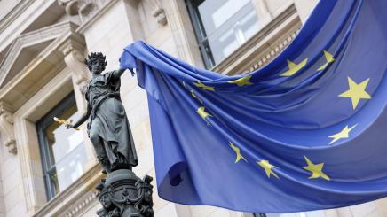 Eine Europa-Flagge, mit ihrem Kranz aus fünf goldenen fünfzackigen Sternen, hat sich in einer Statue am Reichstag verfangen.