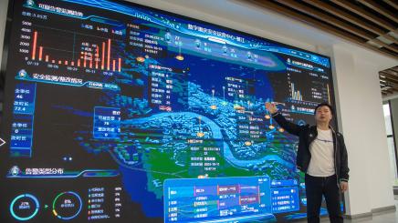A staff member presents graphics on a screen in a cyber security monitor center in Qijiang District