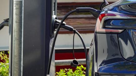 An electric car connects to a public charging station